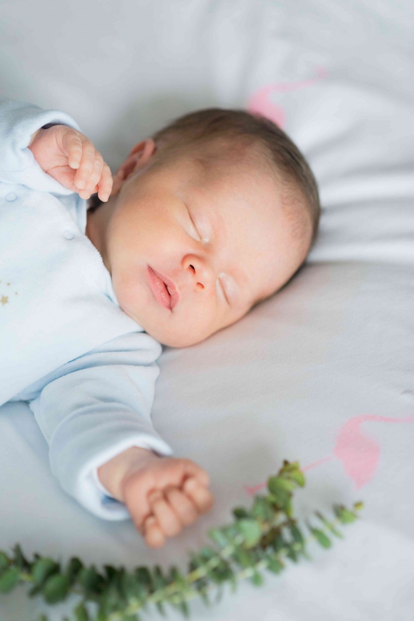 Parent holding newborn at home, natural light