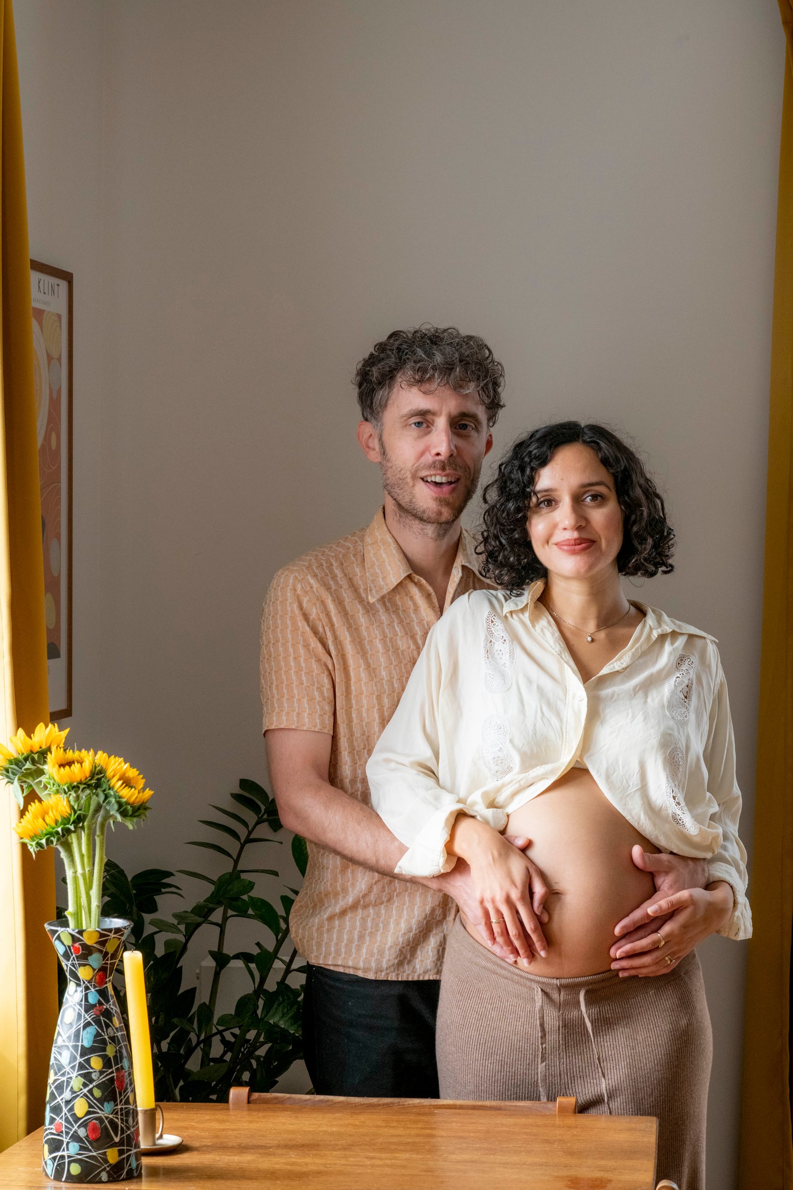 Couple at home in London on a maternity photoshoot, hands on the bump