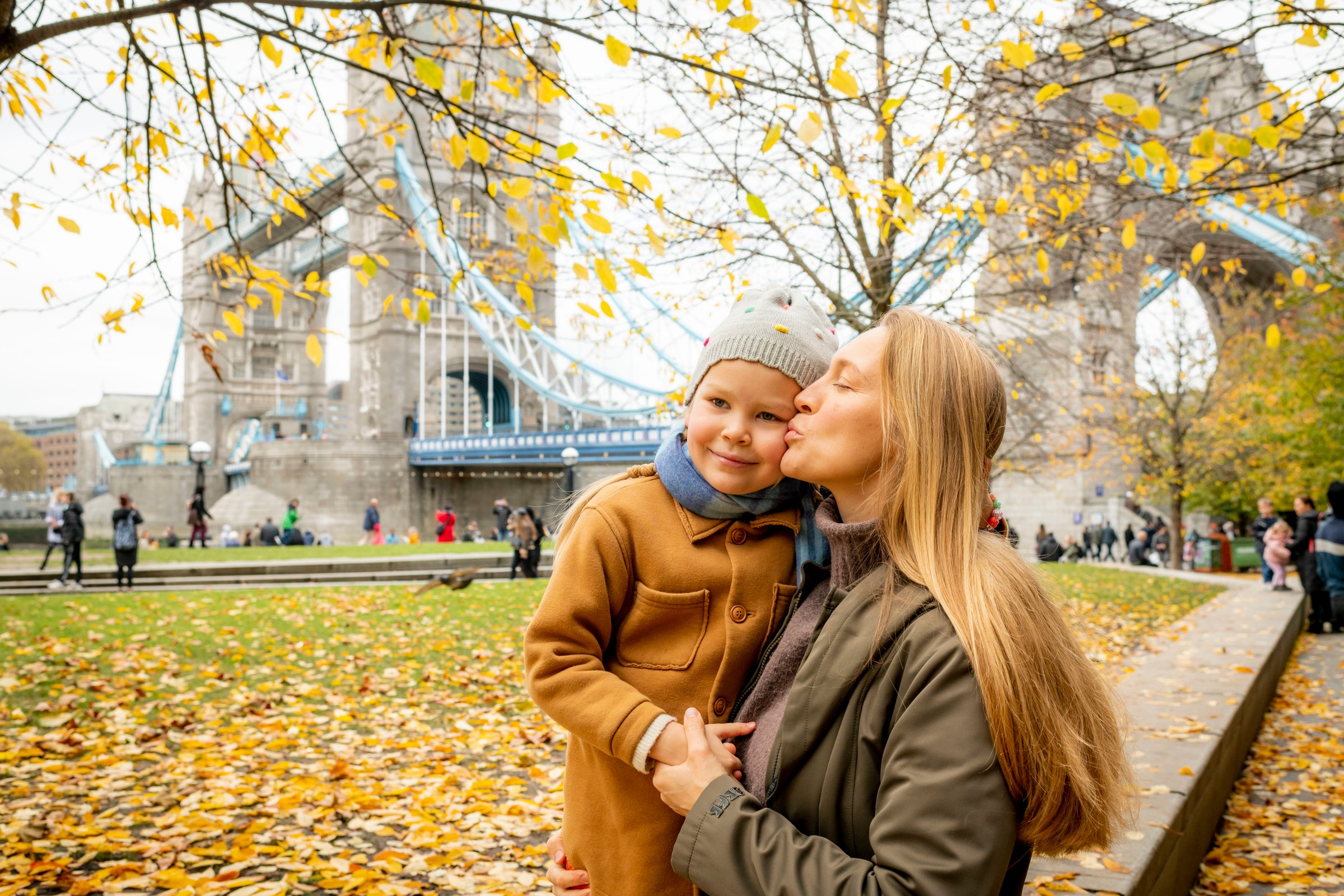 Mum kissing her son by Tower Bridge on an autumn family photoshoot